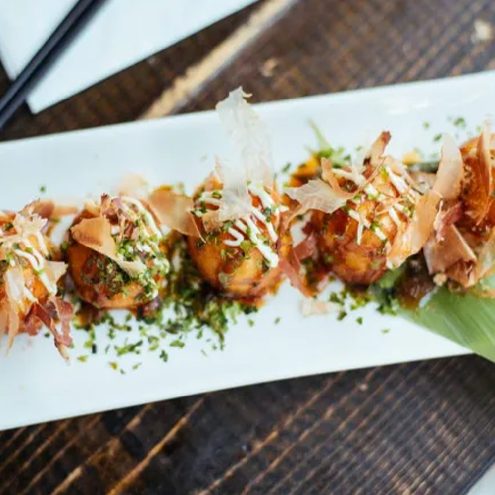 Tempting takoyaki topped with bonito flakes and drizzled sauce